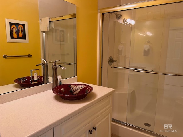 bathroom featuring a shower with shower door and oversized vanity