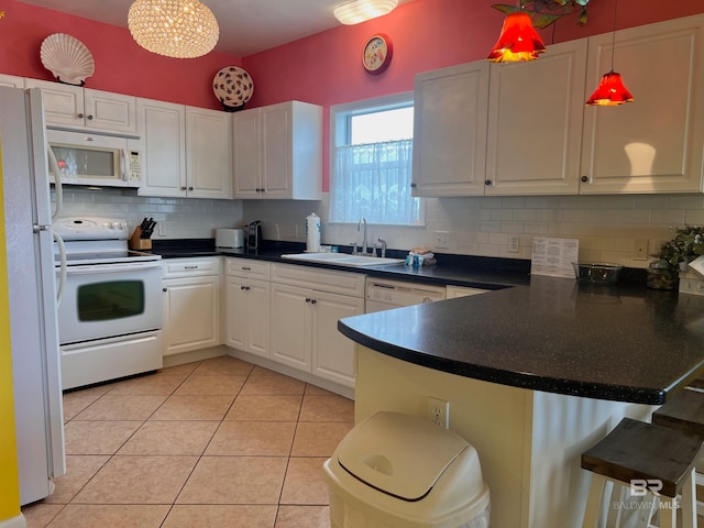 kitchen featuring white cabinetry, sink, backsplash, white appliances, and hanging light fixtures
