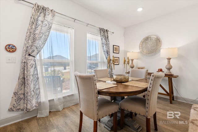 dining room with baseboards, wood finished floors, and recessed lighting