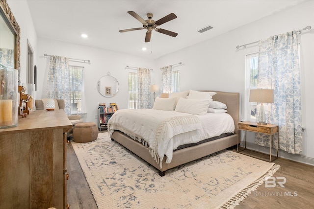 bedroom featuring a ceiling fan, wood finished floors, visible vents, and recessed lighting