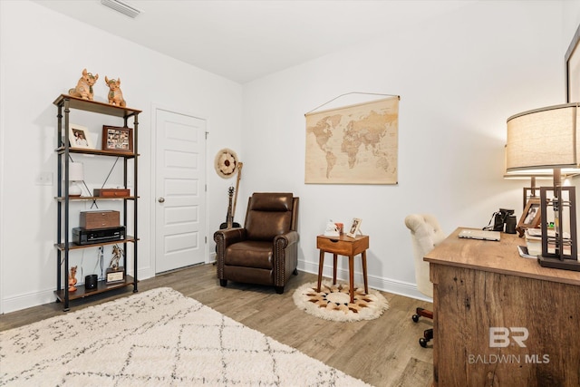 sitting room with visible vents, baseboards, and wood finished floors