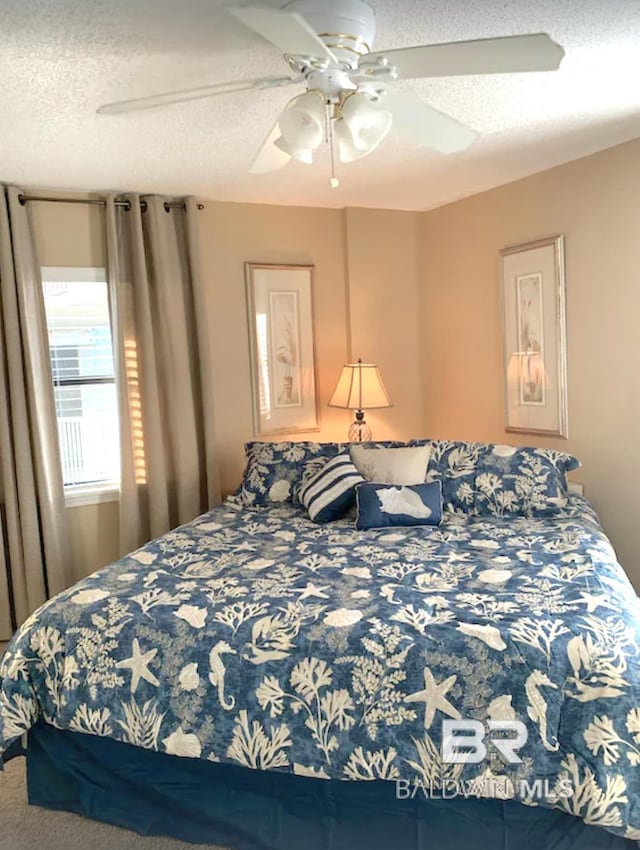 bedroom featuring ceiling fan and a textured ceiling