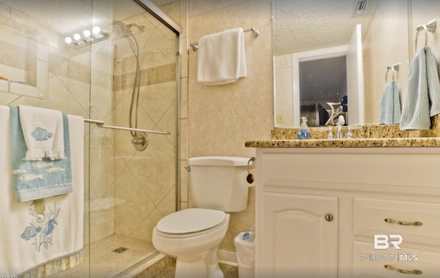 full bath with a textured ceiling, toilet, visible vents, vanity, and a shower stall