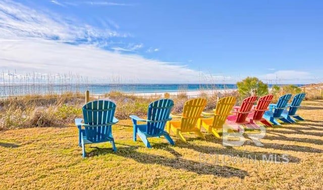 exterior space featuring a view of the beach, a water view, and a yard