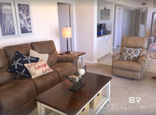 living room with visible vents, light colored carpet, and light tile patterned flooring