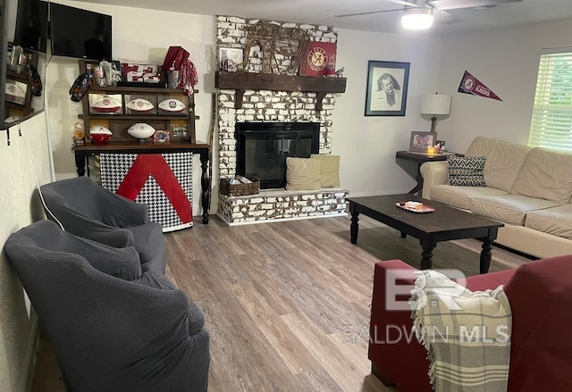 living room featuring a brick fireplace, ceiling fan, and hardwood / wood-style flooring