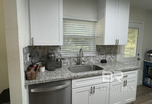 kitchen with dishwasher, decorative backsplash, white cabinetry, and sink