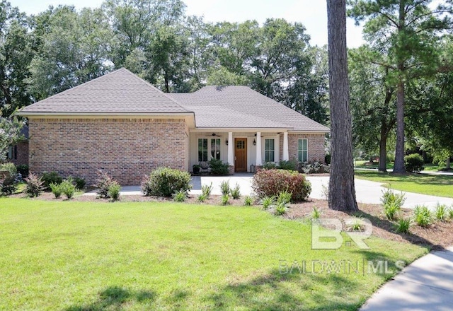 ranch-style house with a front yard, covered porch, brick siding, and roof with shingles