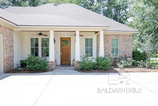 view of front of property featuring a shingled roof, covered porch, brick siding, and ceiling fan