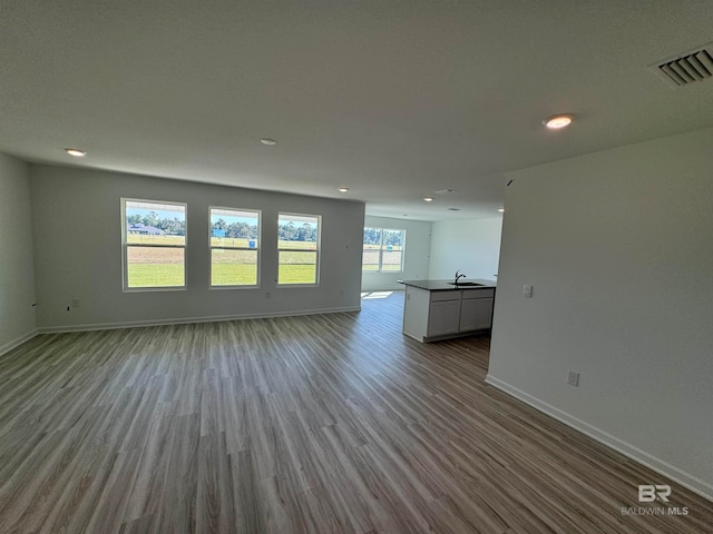 unfurnished living room featuring light hardwood / wood-style floors and sink