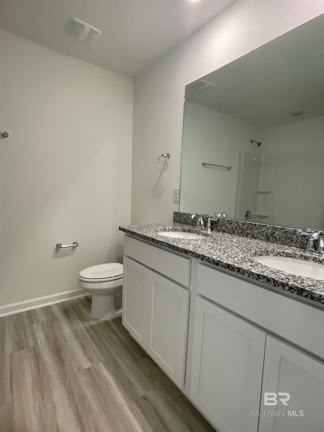 bathroom with vanity, hardwood / wood-style flooring, toilet, and walk in shower