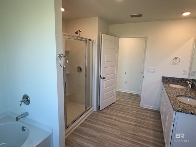 bathroom featuring vanity, plus walk in shower, and hardwood / wood-style flooring