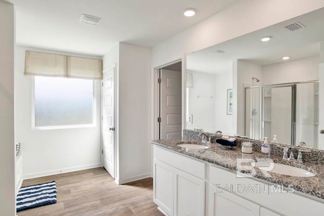 bathroom with hardwood / wood-style flooring, vanity, and walk in shower