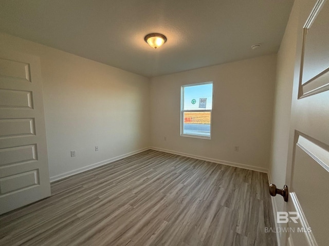 unfurnished room with hardwood / wood-style flooring