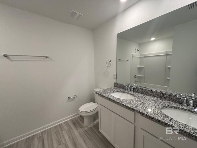 full bathroom with vanity, wood-type flooring,  shower combination, and toilet