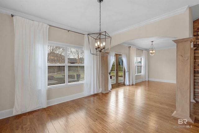 unfurnished dining area featuring ornamental molding, light hardwood / wood-style flooring, and a notable chandelier