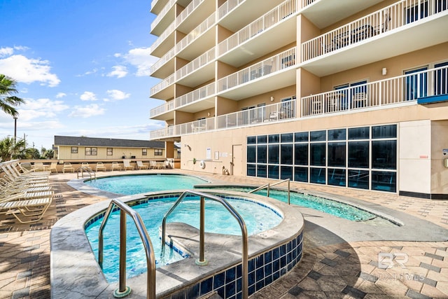 view of swimming pool with a hot tub