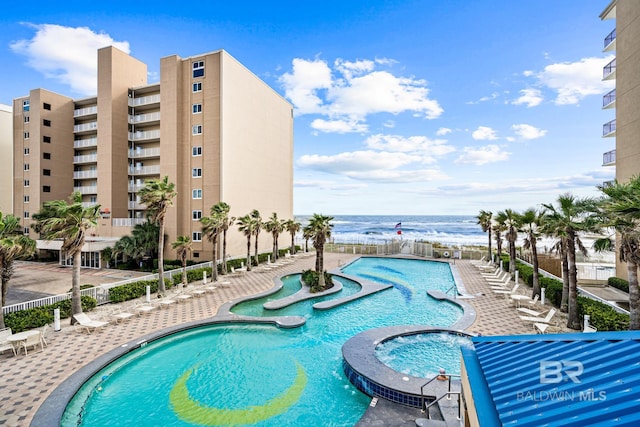 view of swimming pool with a community hot tub, a patio area, and a water view