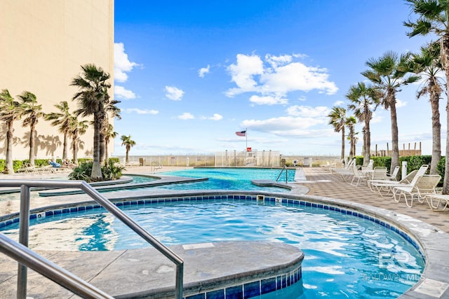 view of swimming pool featuring a hot tub