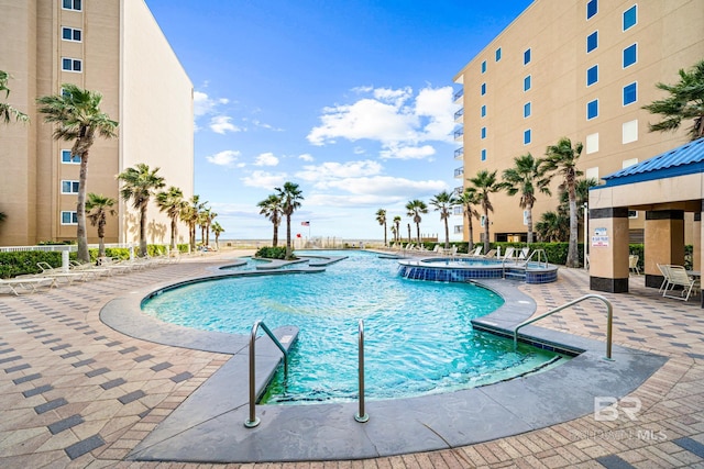 view of swimming pool with a hot tub and a patio