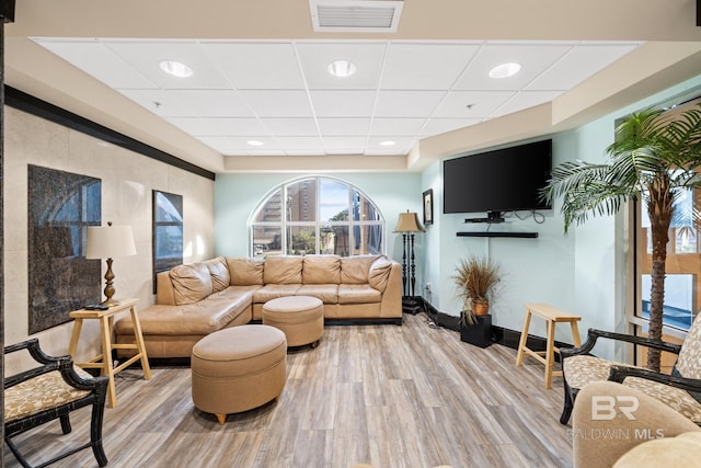 living room featuring a paneled ceiling and hardwood / wood-style flooring