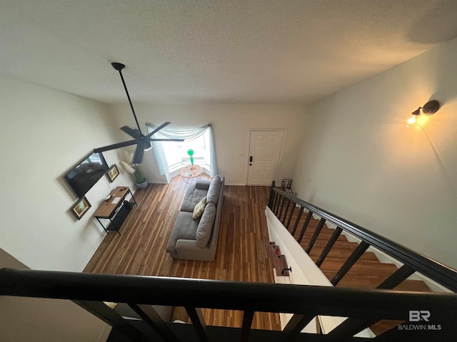 stairs featuring a textured ceiling and dark wood-type flooring