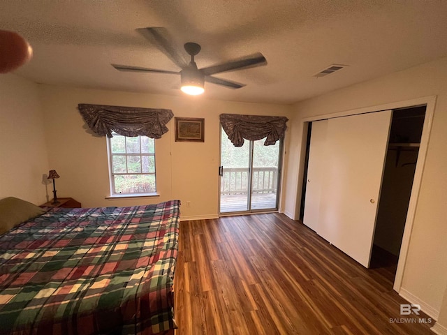 unfurnished bedroom featuring a closet, dark hardwood / wood-style floors, ceiling fan, access to outside, and a textured ceiling