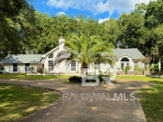 view of front of property with a front lawn, driveway, and a chimney