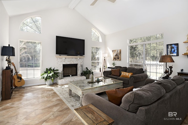 living room with a brick fireplace, baseboards, beamed ceiling, high vaulted ceiling, and a ceiling fan