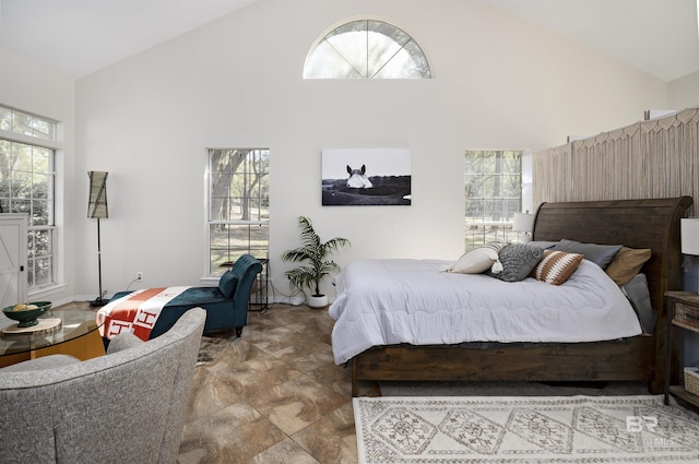bedroom featuring multiple windows and high vaulted ceiling