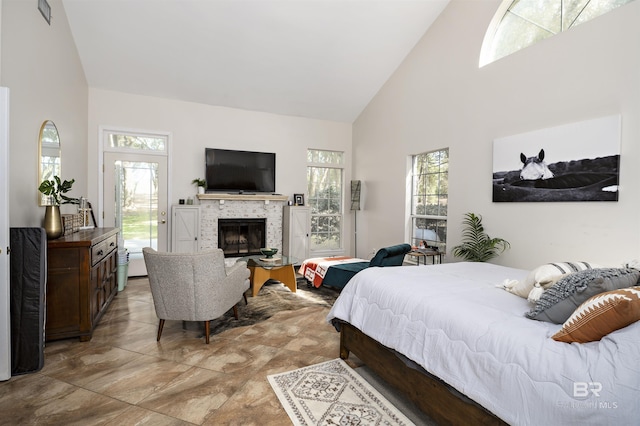 bedroom featuring a fireplace and high vaulted ceiling