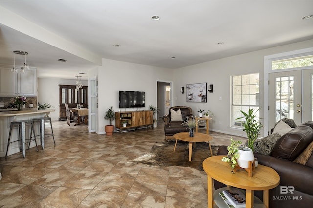 living room featuring plenty of natural light, recessed lighting, visible vents, and baseboards