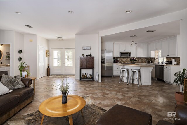 living area featuring visible vents, recessed lighting, and french doors