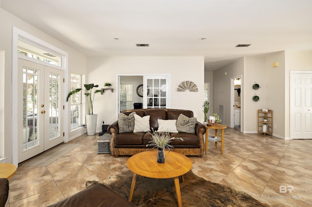 living room featuring french doors, visible vents, and baseboards