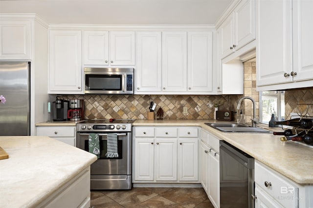 kitchen with a sink, stainless steel appliances, white cabinets, and light countertops