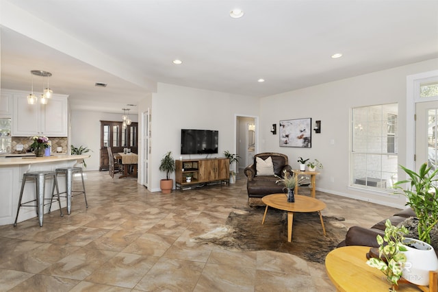living room featuring plenty of natural light, recessed lighting, visible vents, and baseboards