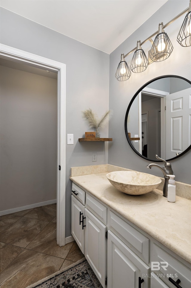 bathroom with tile patterned floors, baseboards, and vanity