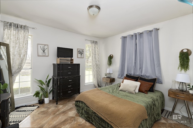bedroom with multiple windows and baseboards