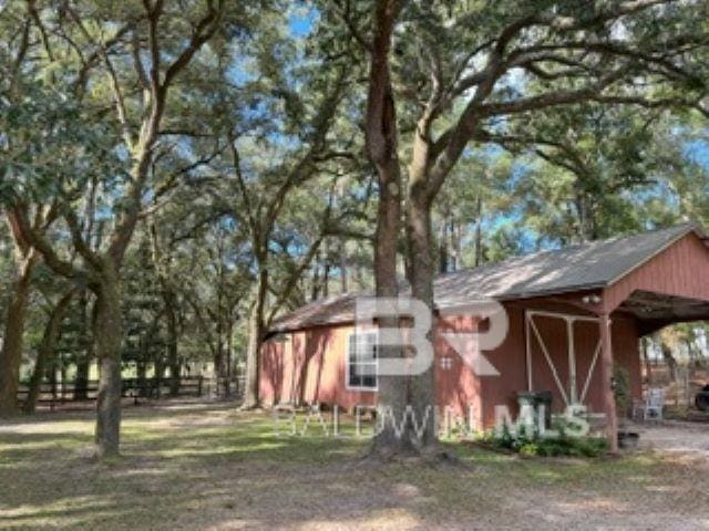 exterior space with an outdoor structure, a carport, and fence