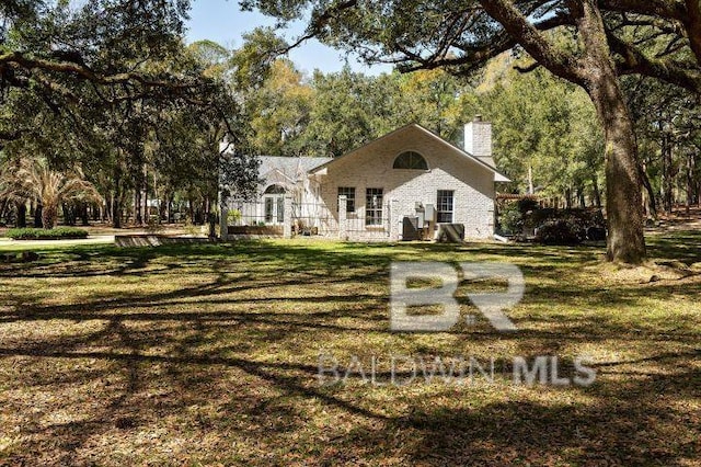 view of front of property featuring a lawn and a chimney