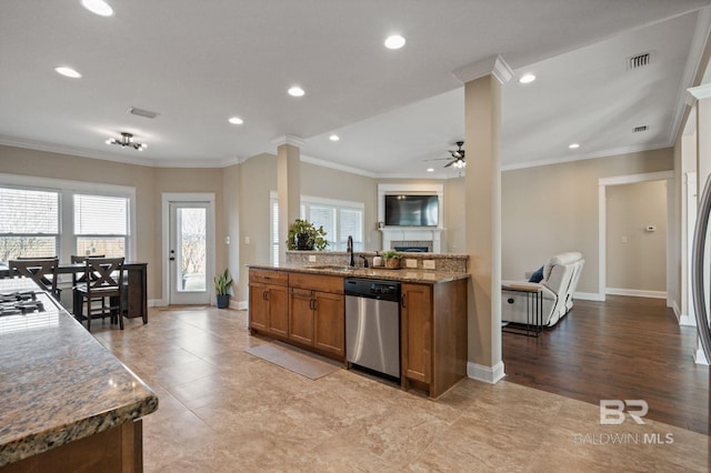 kitchen featuring crown molding, ornate columns, appliances with stainless steel finishes, and dark stone countertops