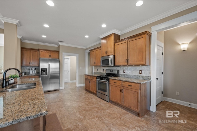 kitchen featuring light stone counters, sink, decorative backsplash, and appliances with stainless steel finishes