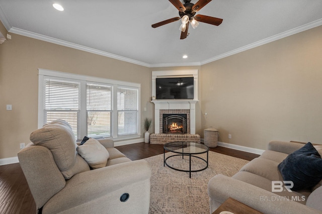 living room featuring hardwood / wood-style floors, a fireplace, ornamental molding, and ceiling fan