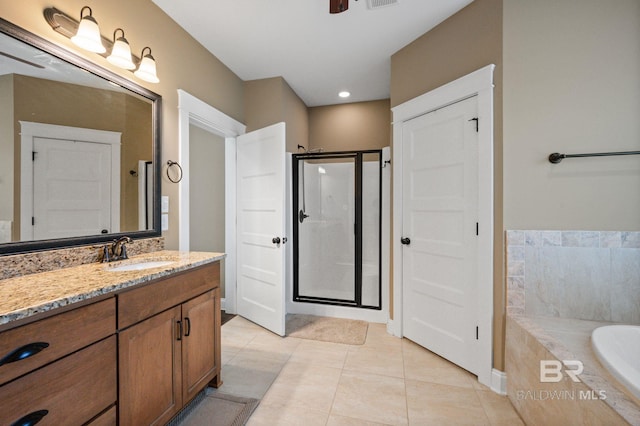 bathroom with tile patterned floors, vanity, and shower with separate bathtub