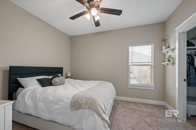 carpeted bedroom featuring ceiling fan and a closet