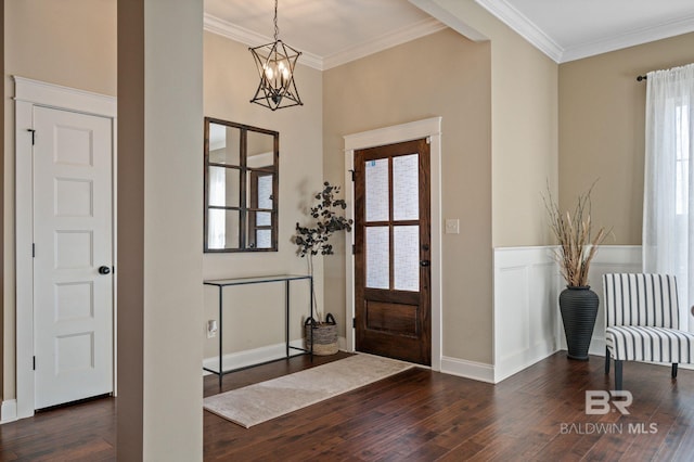 foyer with an inviting chandelier, crown molding, and dark wood-type flooring