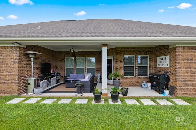 rear view of house featuring ceiling fan, an outdoor living space, a yard, and a patio