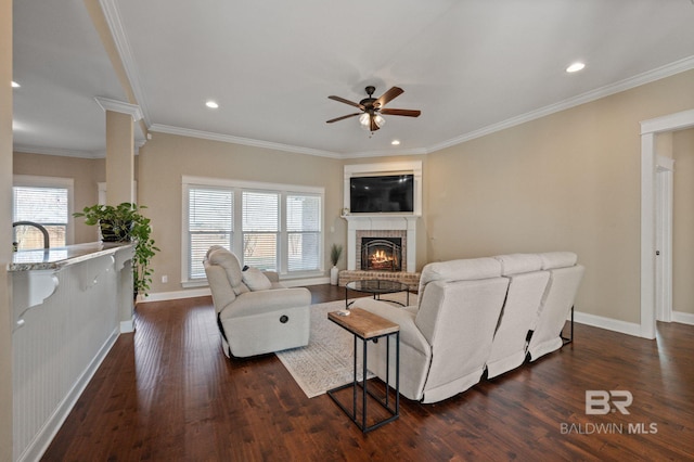 living room featuring a brick fireplace, dark hardwood / wood-style floors, and a wealth of natural light