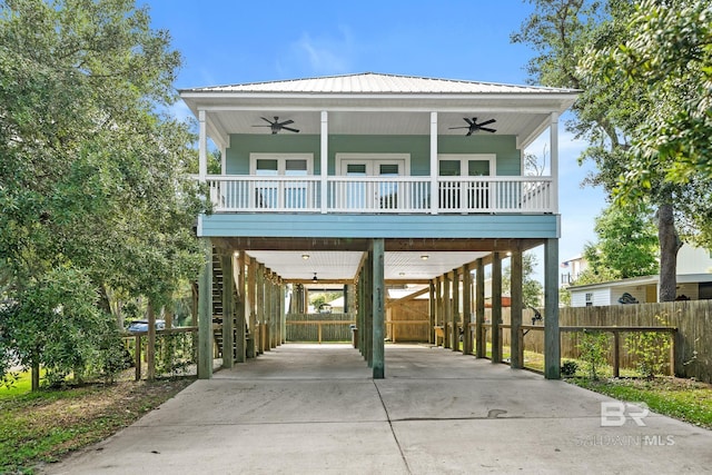 coastal inspired home featuring covered porch, a carport, and ceiling fan