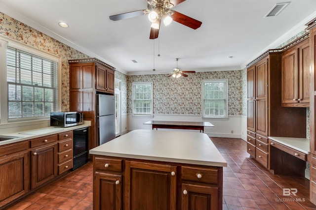kitchen featuring wallpapered walls, stainless steel appliances, light countertops, and a center island
